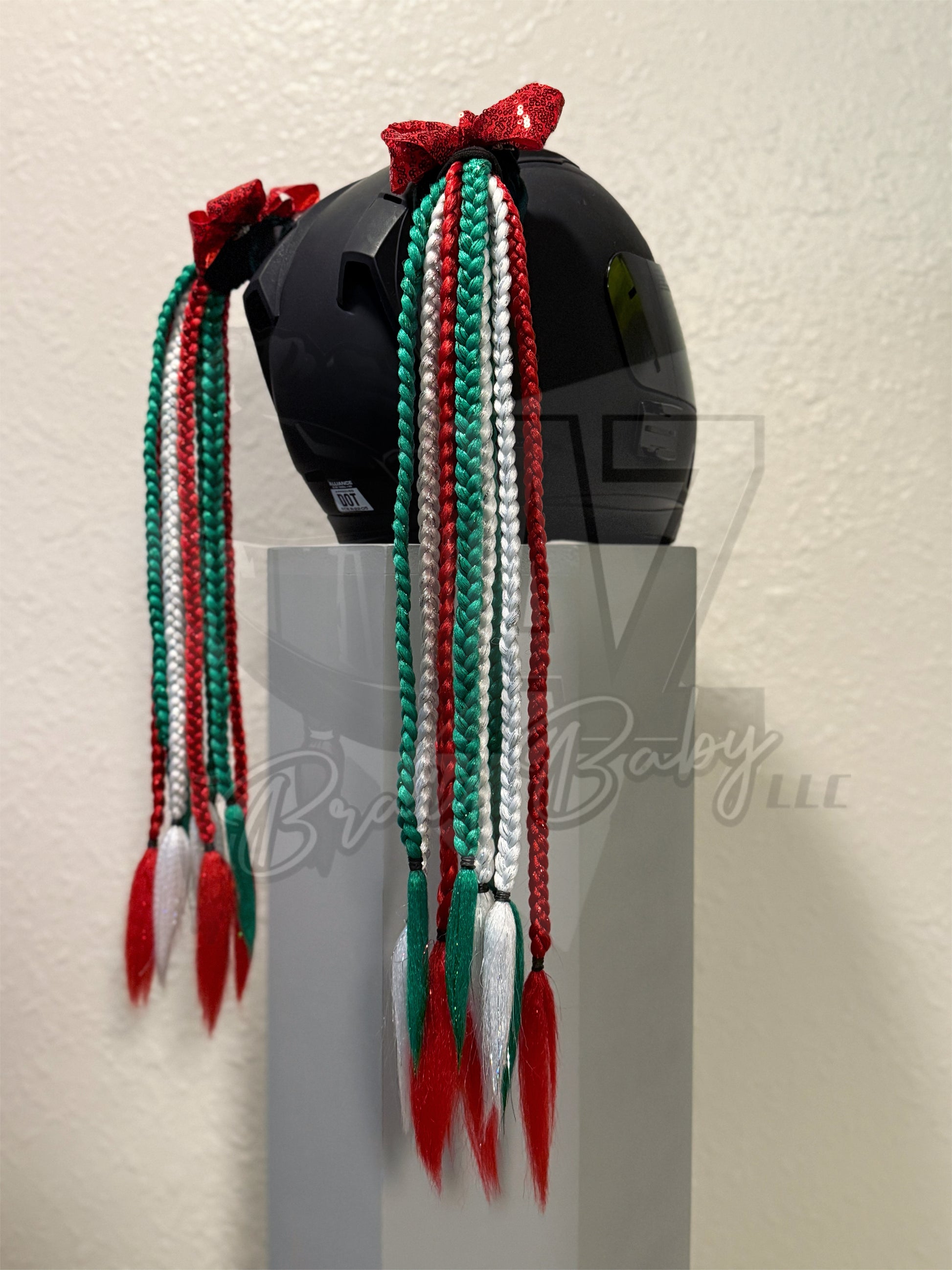 Custom motorcycle helmet braids featuring green, red, and white braids with tinsel and sequin bows